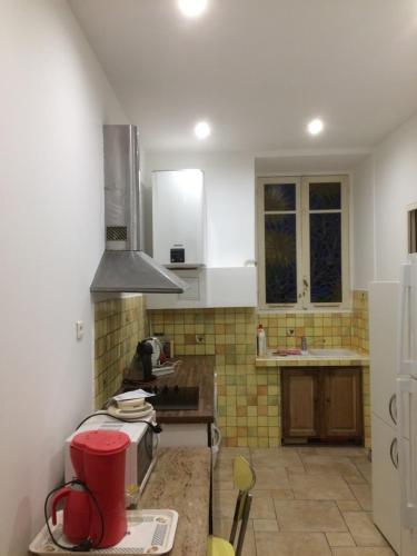 une cuisine avec un évier et une cuisinière dans l'établissement F2 centre Bastia, à Bastia