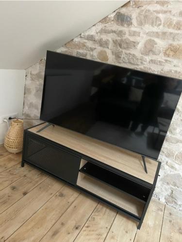 a large flat screen tv sitting in a living room at Loft lumineux et cosy avec grande terrasse in Maîche