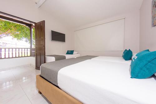 Ayenda Isla de Manga في كارتاهينا دي اندياس: غرفة نوم بيضاء مع سريرين ونافذة