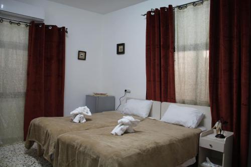 two stuffed animals sitting on top of a bed at Canawati Apartment in Bethlehem