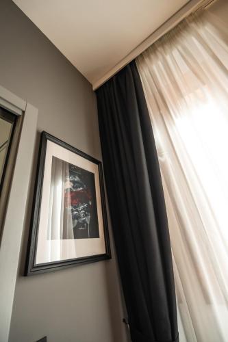 a picture hanging on a wall next to a window at Relais Manzoni in Rome
