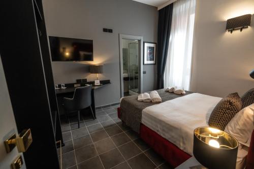 a hotel room with a bed and a desk at Relais Manzoni in Rome