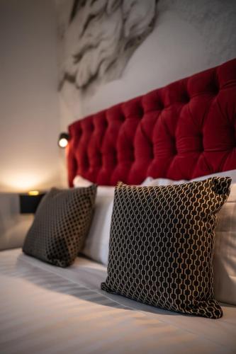 a bed with a red headboard and two pillows at Relais Manzoni in Rome