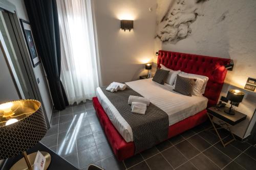 a bedroom with a large bed with a red headboard at Relais Manzoni in Rome
