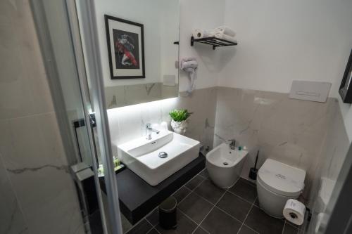 a white bathroom with a sink and a toilet at Relais Manzoni in Rome