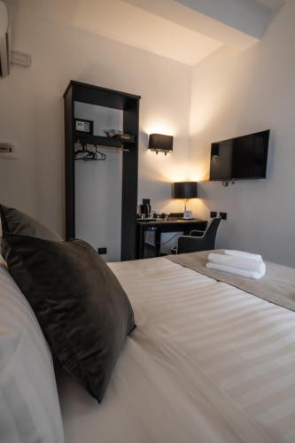 a bedroom with a bed and a desk with a computer at Relais Manzoni in Rome