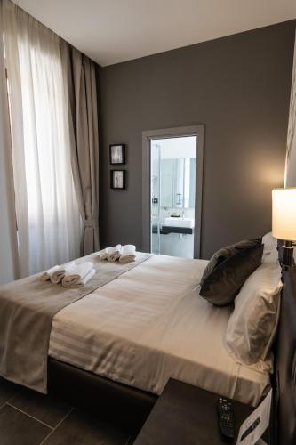a bedroom with a large bed with towels on it at Relais Manzoni in Rome