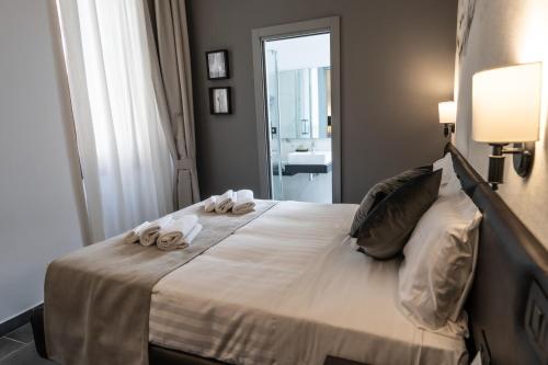 a bedroom with a large bed with towels on it at Relais Manzoni in Rome