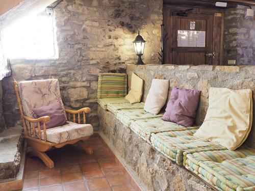 a stone wall with a couch and a chair at Casa Tomaso - Turismo Rural in Reperos