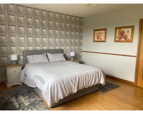 a bedroom with a large bed and two night stands at Castleview, Spacious 5 bedroom house with stunning views in Forkill