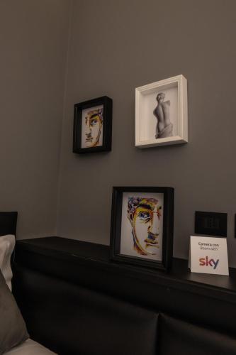 a shelf with three framed pictures on a wall at Relais Manzoni in Rome