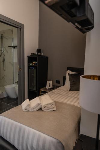 a bedroom with a bed with towels on it at Relais Manzoni in Rome
