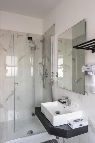 a white bathroom with a sink and a shower at Relais Manzoni in Rome