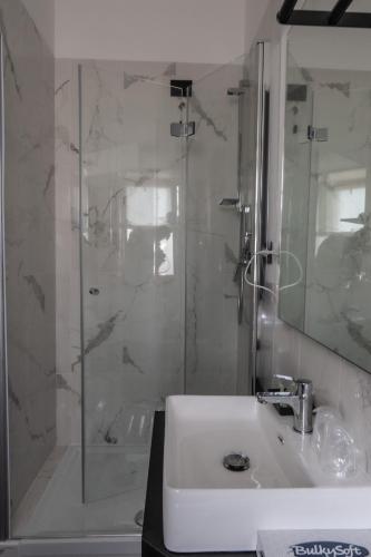 a white bathroom with a sink and a shower at Relais Manzoni in Rome