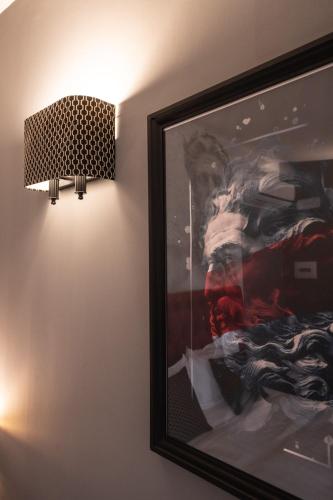 a picture hanging on a wall next to a lamp at Relais Manzoni in Rome