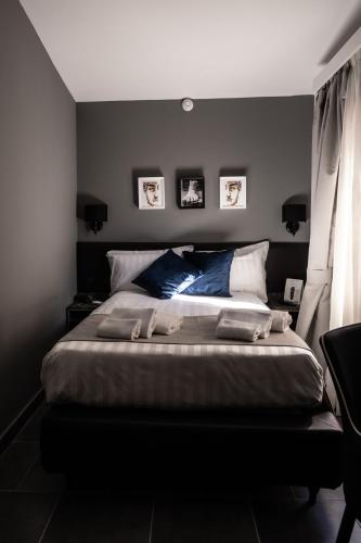 a bedroom with a large bed with blue pillows at Relais Manzoni in Rome
