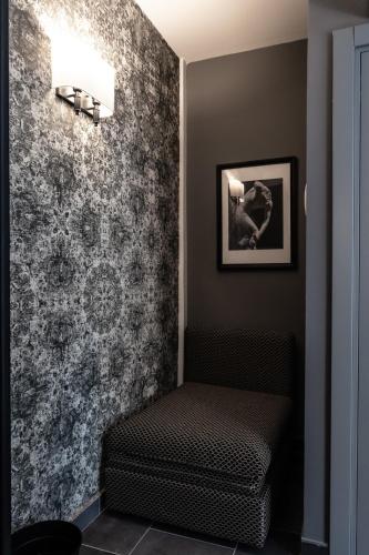 a room with a bench and a wall with wallpaper at Relais Manzoni in Rome