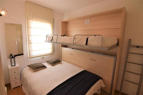ein kleines Schlafzimmer mit zwei Etagenbetten darin in der Unterkunft 394-Duplex moderno cerca playa y en pleno centro in Empuriabrava
