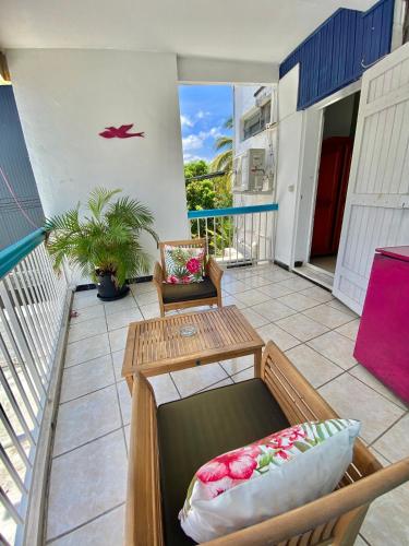 a balcony with a table and a chair at Hotel De la Plage in Saint-Gilles les Bains