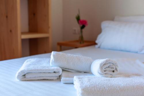 a bed with towels and a vase with a flower at Toni Retzo Rooms in Himare