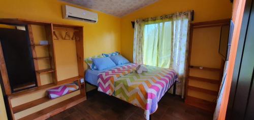 Un dormitorio pequeño con una cama y una ventana. en Tío King Hospedaje Turístico, en Uvita