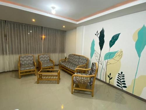 a waiting room with chairs and a wall with flowers at Departamento Los Ángeles - Valle de Los Chillos in Sangolquí