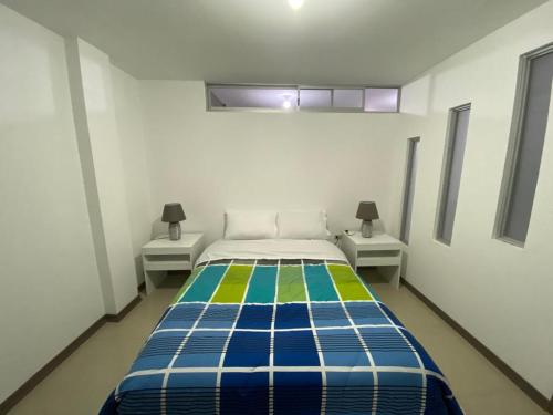 a bedroom with a bed and two night stands at Departamento Los Ángeles - Valle de Los Chillos in Sangolquí