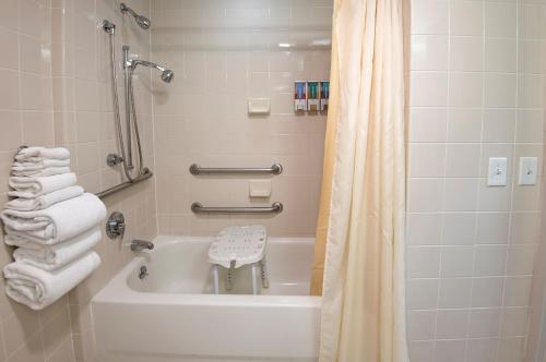 a bathroom with a tub and a shower with towels at Rough River Dam State Resort Park in Fentress McMahan