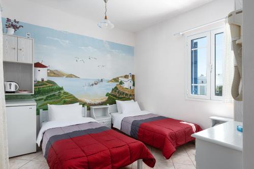 2 camas en una cocina con una pintura en la pared en Noe Rooms, en Tinos