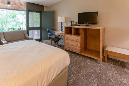 a bedroom with a bed and a tv and a desk at Rough River Dam State Resort Park in Fentress McMahan