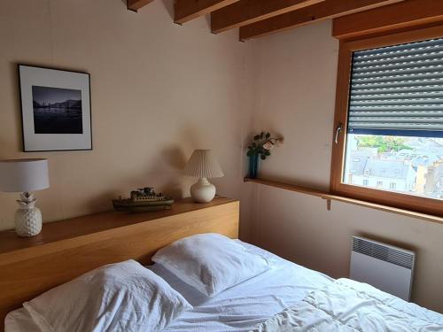 Schlafzimmer mit einem Bett und einem Fenster in der Unterkunft Maison Le Palais, 3 pièces, 4 personnes - FR-1-418-86 in Le Palais