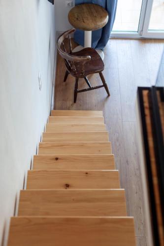 a wooden staircase with a chair and a table at Toni Retzo Rooms in Himare