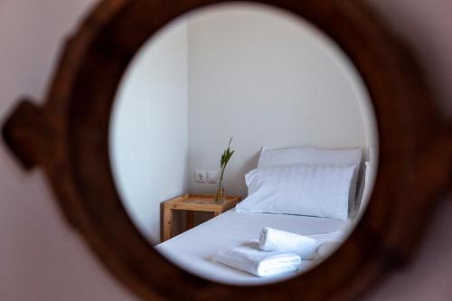 a mirror reflecting a bed with two towels on it at Toni Retzo Rooms in Himare