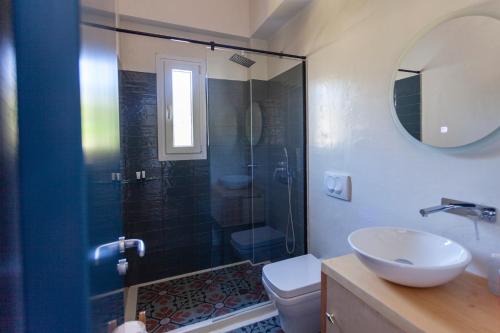 a bathroom with a shower and a toilet and a sink at Toni Retzo Rooms in Himare