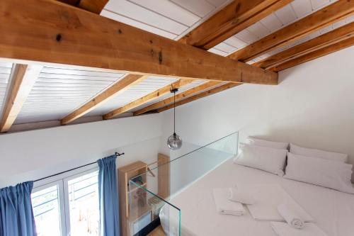 a room with white walls and wooden ceilings at Toni Retzo Rooms in Himare