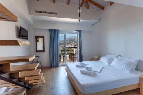 a bedroom with a large bed and a balcony at Toni Retzo Rooms in Himare