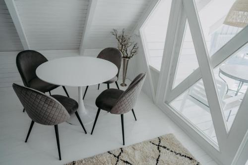 a table and chairs in a room with a window at Seehütte Neusiedlersee - Strandhaus, Elektroboot inklusive in Rust