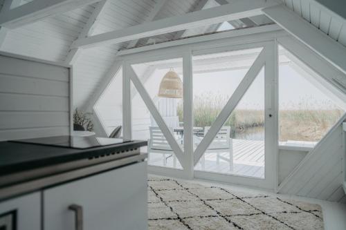 a kitchen with a large window and a stove at Seehütte Neusiedlersee - Strandhaus, Elektroboot inklusive in Rust
