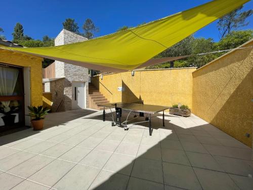 a yellow canopy on a patio with a table at Gîtes Le Bouzet in Salavas