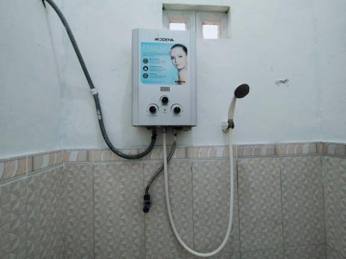 y baño con ducha y aitizer. en SUPER OYO 2873 Griya Annisa, en Tegal
