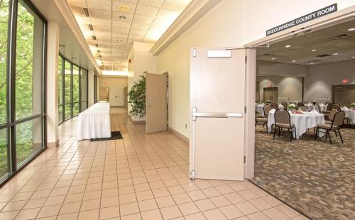 a banquet hall with tables and chairs and a refrigerator at Rough River Dam State Resort Park in Fentress McMahan