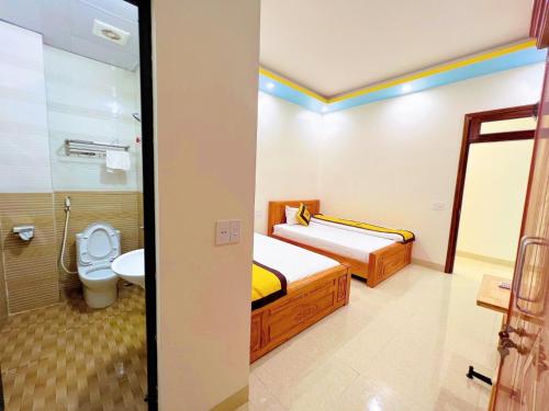 Habitación con baño con 2 camas y aseo. en Khách Sạn Nhà Hàng Lương Gia en Ha Giang