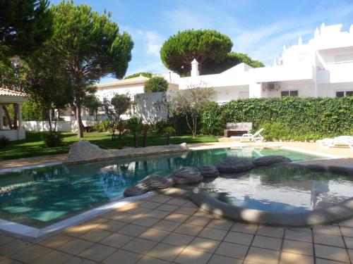 a swimming pool in front of a house at Jardins da Falesia in Albufeira