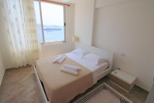 a bedroom with a bed with two towels on it at Skyview Apartments in Sarandë