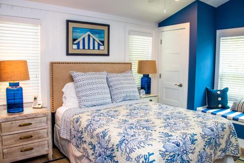 una camera da letto con letto e pareti e finestre blu di Island Time: AMI North End, Pool, Close to City Pier & Pine Ave by Anna Maria Life Vacation Rentals ad Anna Maria