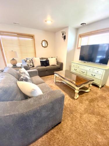 a living room with a couch and a large television at The Raspberry Garden in Rexburg