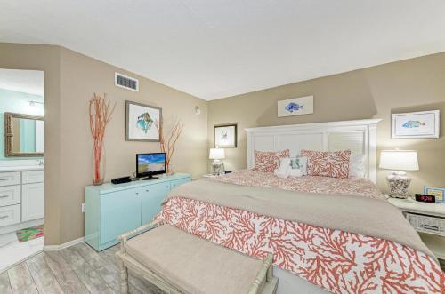 a bedroom with a large bed and a television at Sunset Beach 102: Gulf Front, Stunning Views, On the Beach, Pool by Anna Maria Life Vacation Rentals in Holmes Beach