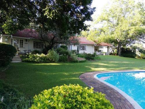 un patio con una casa y una piscina en Tiree B&B, en Johannesburgo