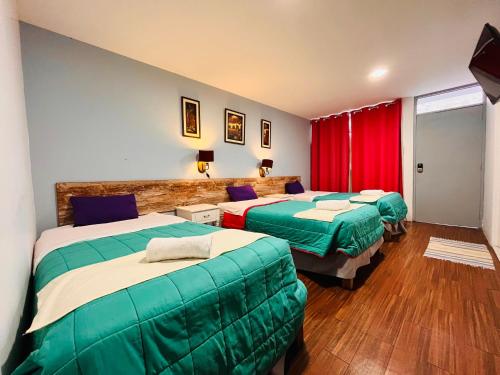 a hotel room with two beds and a red curtain at Chikan Hoteles in Arequipa