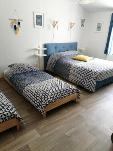 two beds in a room with wooden floors at Chez Isa et Christophe in Mogeville